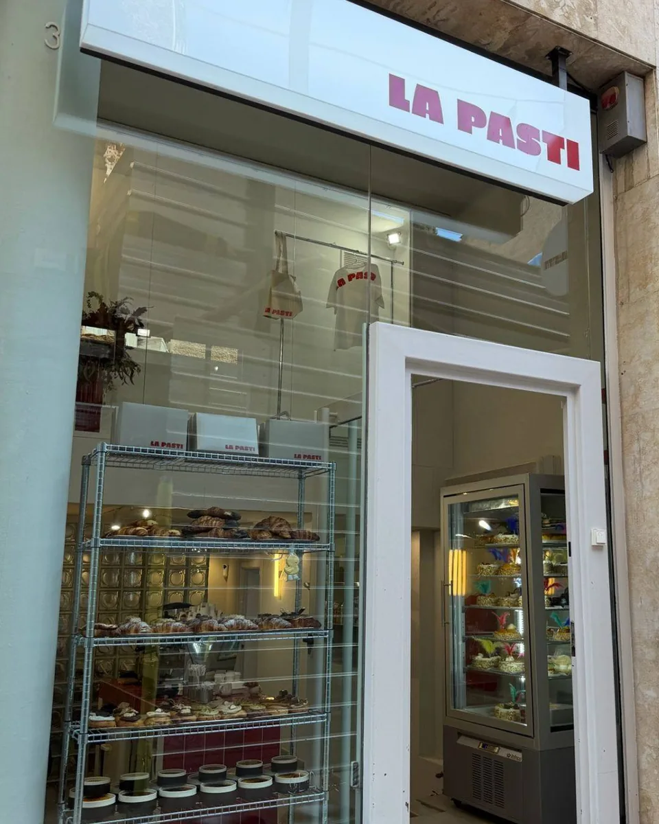 Façana de la botiga de La Pasti amb el rètol i les vitrines plenes de brioixeria