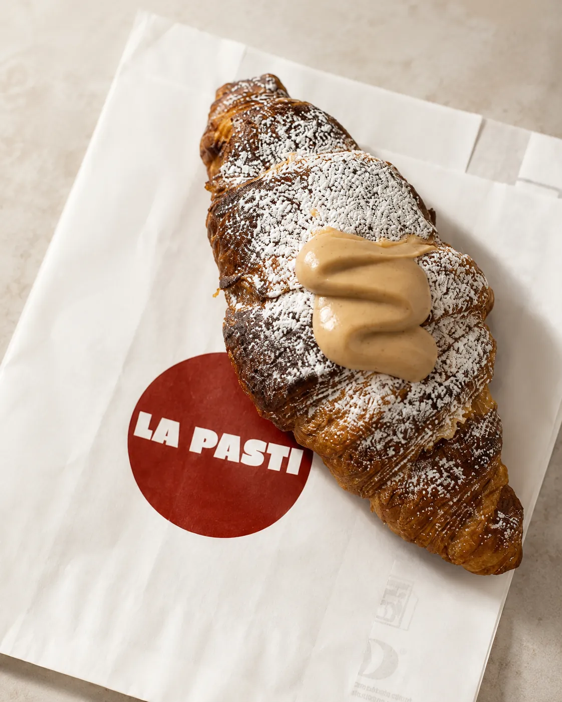 Croissant de La Pasti amb crema sobre la bossa de la marca